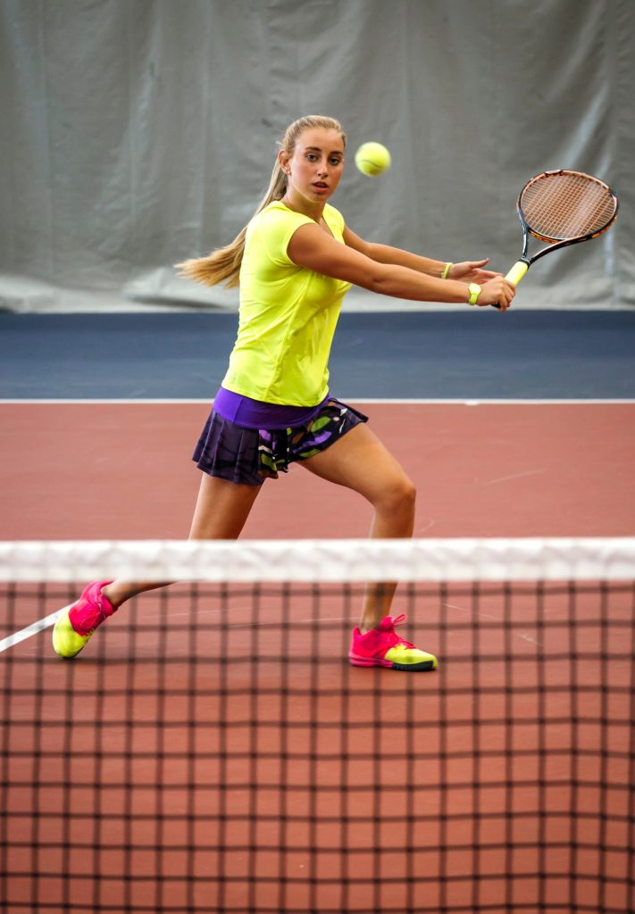 Young woman playing tennis in an indoor tennis center